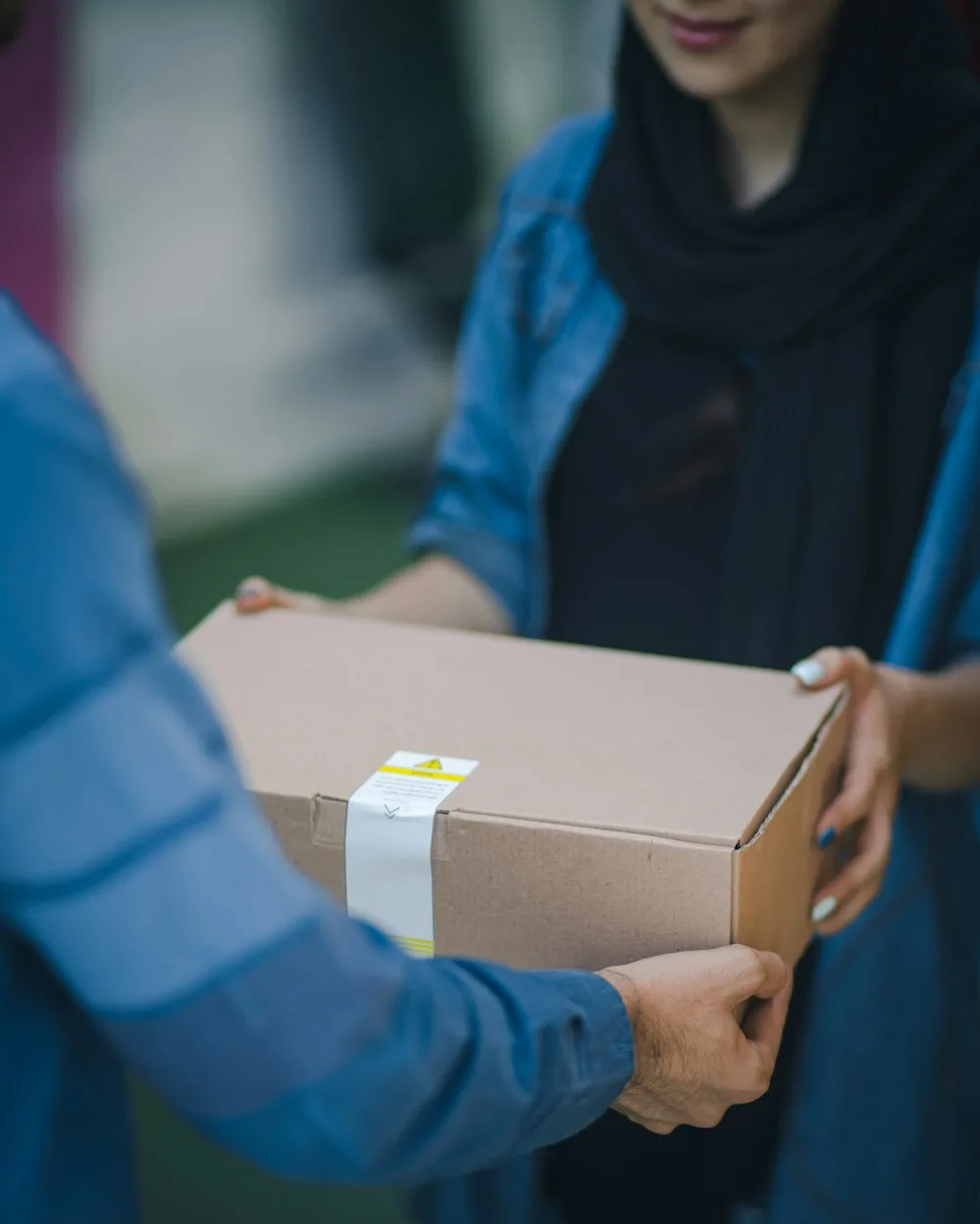 A WOOW courier delivering a customs-cleared international parcel to a doorstep in Dhaka, Bangladesh